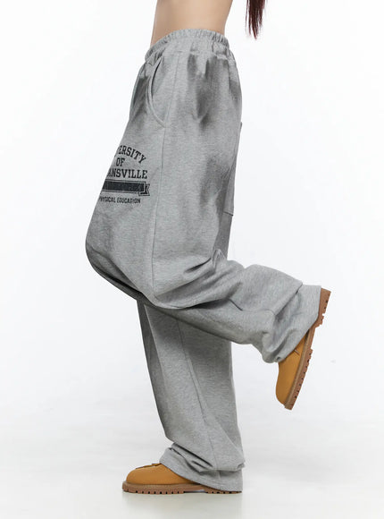 Graphic Wide Leg Sweatpants CL527 Gray side shot on model with leg raised showing oversized silhouette and side Evansville lettering down left leg