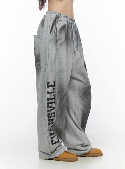 Graphic Wide Leg Sweatpants CL527 Gray side shot on model standing straight showing drawstring waist side pocket and vertical Evansville letter print