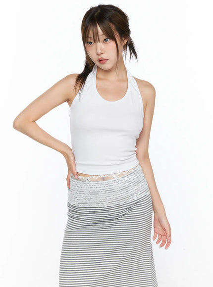Halter Crop Top CL517 White front view on model with hands on hip, ribbed knit halter crop silhouette, styled with striped midi skirt