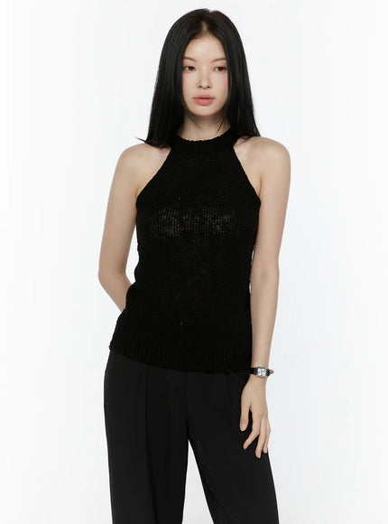 Halter Knit Top IL506 Black front half-body shot on model one hand in pocket showing halter neckline semi-sheer open knit texture ribbed hem with watch styling
