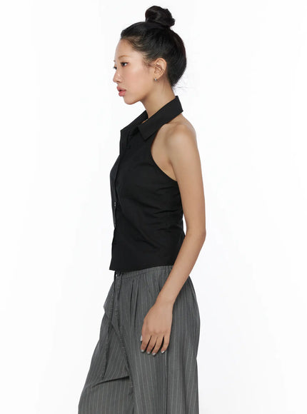 Halter Sleeveless Shirt CL510 Black side shot on model facing left, open back halter neckline visible, cropped hem, grey pinstripe wide-leg trousers