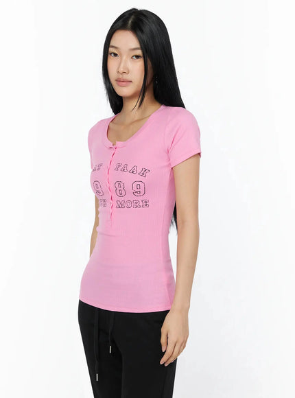 Henley Graphic Tee IL509 Pink side-angle shot model looking right hand on hip showing fitted ribbed side profile and partial graphic print detail