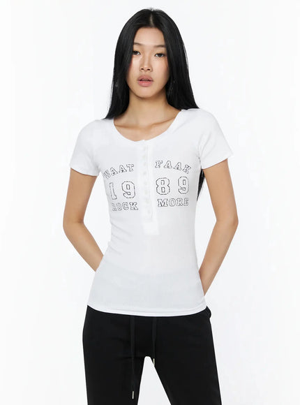 Henley Graphic Tee IL509 White front shot model standing straight showing WAAT FAAK 1989 ROCK MORE graphic print and button placket ribbed fabric