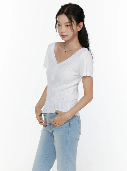 Henley Short Sleeve Tee CL521 White angled three-quarter front shot model hand on hip showing slim fit pointelle ribbed knit and deep V-neckline with button detail