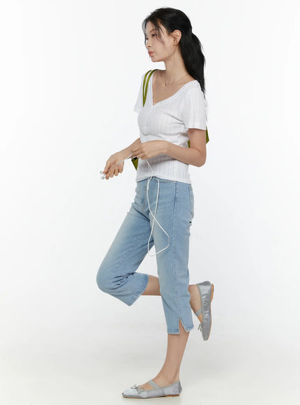 Henley Short Sleeve Tee CL521 White side shot model in profile walking pose wearing fitted pointelle knit tee tucked into light blue capri jeans with silver ballet flats