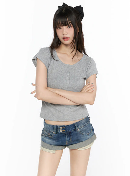 Henley Short Sleeve Tee CL523 Gray front view on model with arms crossed, ribbed henley crop tee with cap sleeves styled with denim shorts