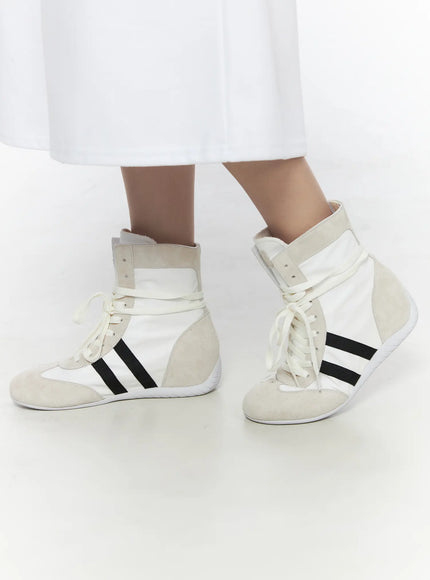 High Top Sneakers CL527 White angled close-up on model both feet, nylon upper with suede overlays and cream flat laces tied at front