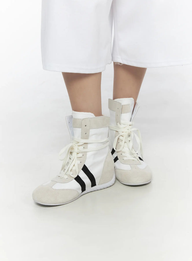 LEWKIN High Top Sneakers CL527 White side close-up on model wearing white wide-leg pants, suede toe cap and black stripe detail visible