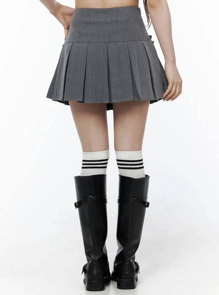 High-Waist Bow Pleated Skirt IL506 Dark gray back view on model showing smooth high waistband and full box pleats, styled with black knee-high boots