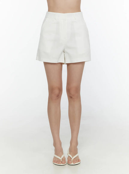 High-Waist Cotton Shorts CL521 White front close-up on model showing tailored waistband center seam and hem detail with white flip-flops