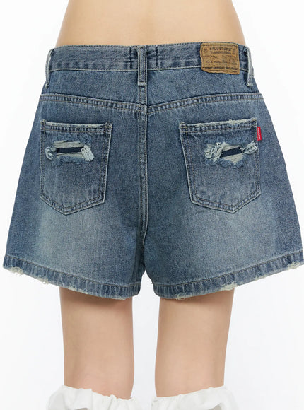 High-Waist Denim Jorts CU530 Dark blue back full-length shot on model showing distressed back pockets, red brand tab, and frayed hem with knee-high boots