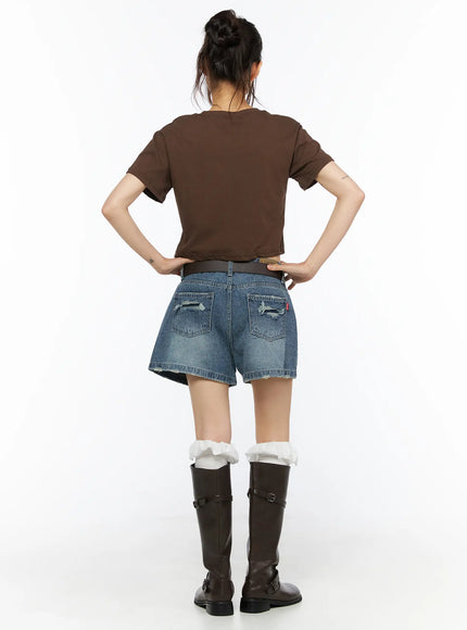 High-Waist Denim Jorts CU530 Dark blue front full-length shot on model standing straight showing V-waist, faded wash gradient, and raw hem with brown boots