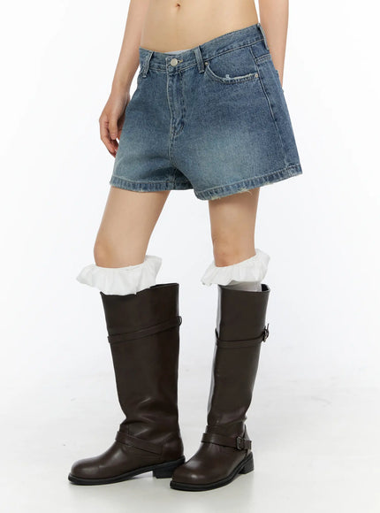 High-Waist Denim Jorts CU530 Dark blue side-view shot on model standing in profile showing relaxed fit silhouette and raw cutoff hem with brown boots