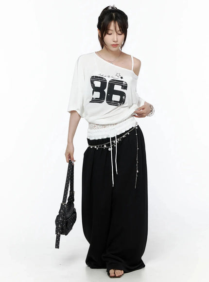 High-Waist Lace Wide Leg Sweatpants IL506 Black full-body front model shot styled with white number 86 graphic tee silver chain belt and polka dot bag