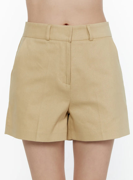 High-Waist Pintuck Shorts CL520 beige close-up front shot on model showing high waistband belt loops and side pocket detail