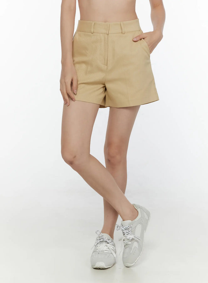 LEWKIN High-Waist Pintuck Shorts CL520 beige three-quarter front shot on model with hand in pocket styled with white sneakers