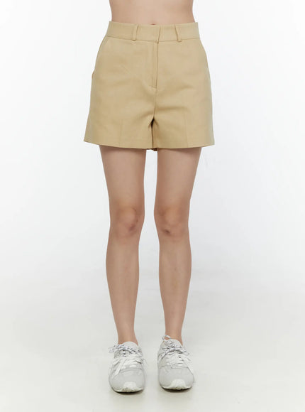 High-Waist Pintuck Shorts CL520 beige front full-length shot on model showing high rise waistband center crease and white sneakers