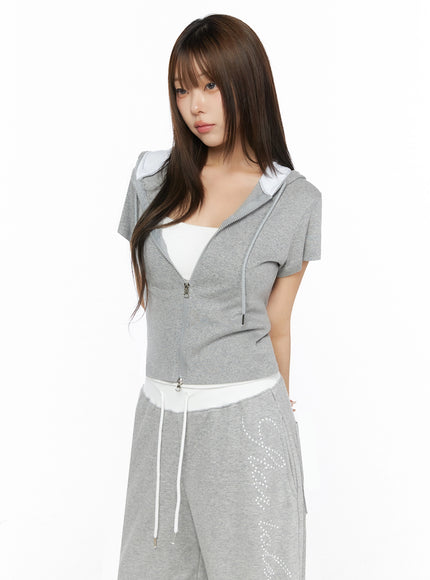Hooded Short Sleeve Zip-Up IL515 Gray three-quarter front view on model showing fitted silhouette zip detail and rhinestone sweatpants