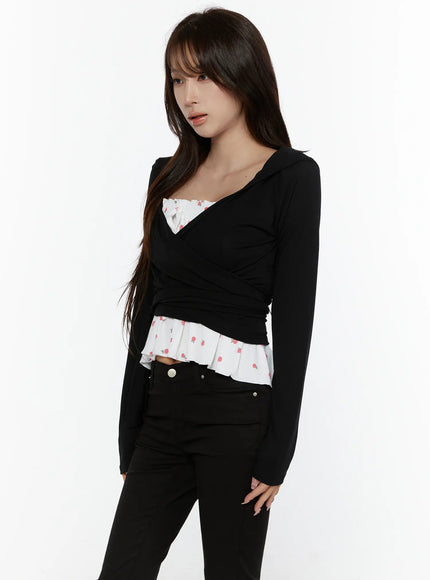 Hooded Wrap Crop Cardigan CL507 Black side shot on model showing wrap silhouette, hooded collar, layered over white rose-print ruffle hem inner top and black jeans