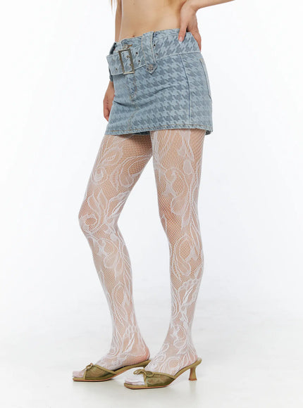 Houndstooth Denim Mini Skirt with Belt CL501 Blue side shot on model hand on hip showing low-rise silhouette houndstooth denim with silver belt buckle and white lace tights