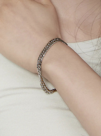 Hudson 6mm Chain Necklace IL517 silver on-model wrist close-up showing polished curb chain bracelet worn against cream fabric background