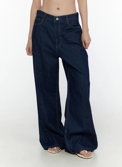 LEWKIN Jael Dark Washed Wide Leg Jeans CL520 Dark blue front close-up on model showing low-rise waistband, silver button, yellow topstitching, and wide-leg denim silhouette