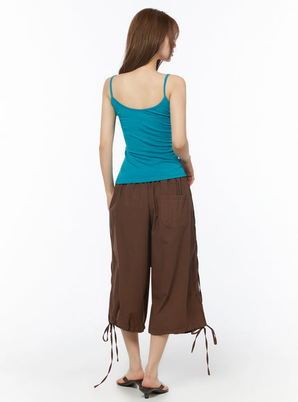 Jelly Flip-Flop Sandals IU525 Brown back shot on model wearing teal spaghetti-strap top and brown wide-leg cargo pants with tie hem detail