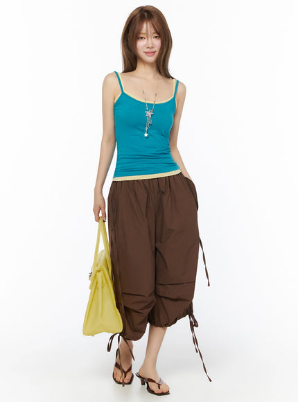 Jelly Flip-Flop Sandals IU525 Brown full front shot on model wearing teal cami top and brown wide-leg cargo pants holding yellow tote bag