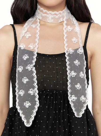 LEWKIN Jinea Ribbon Scarf IL514 White close-up on model styled as choker necktie over black polka dot dress showing scalloped lace edge and floral embroidery detail