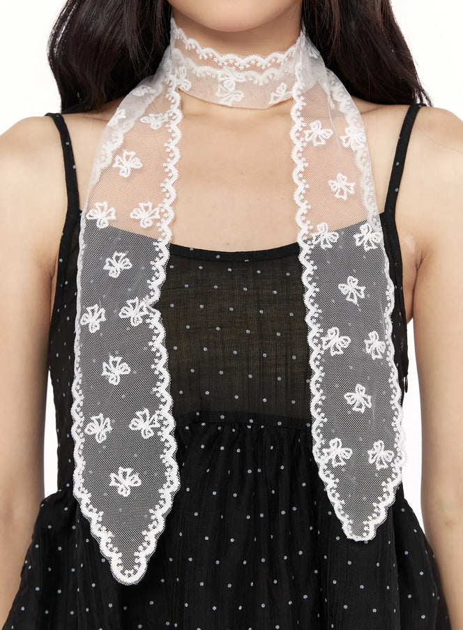 LEWKIN Jinea Ribbon Scarf IL514 White close-up on model styled as choker necktie over black polka dot dress showing scalloped lace edge and floral embroidery detail
