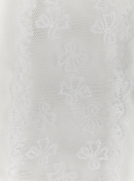 Jinea Ribbon Scarf IL514 White close-up detail of sheer tulle fabric with embroidered floral bow motifs and scalloped lace border trim