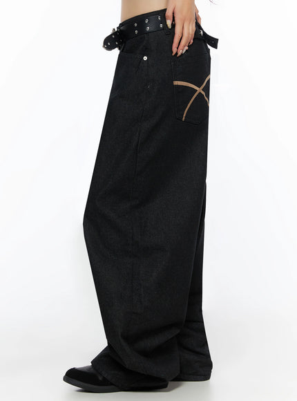 Kairo Back Buckle Wide Jeans IL515 Black side view close-up on model showing tan X-stitch back pocket, studded belt, and dramatic wide-leg denim drape