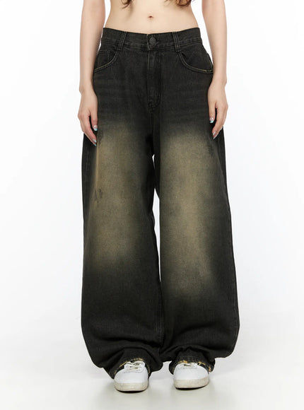 LEWKIN Keisha Washed Baggy Jeans CL523 Black front view on model, cropped waist shot, wide-leg silhouette with yellow-khaki acid wash fade, button closure, sneakers