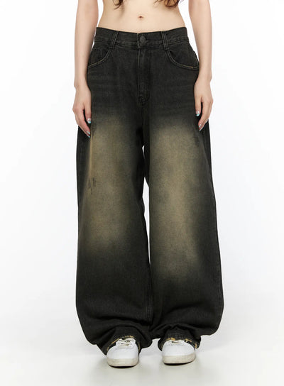 LEWKIN Keisha Washed Baggy Jeans CL523 Black front view on model, cropped waist shot, wide-leg silhouette with yellow-khaki acid wash fade, button closure, sneakers