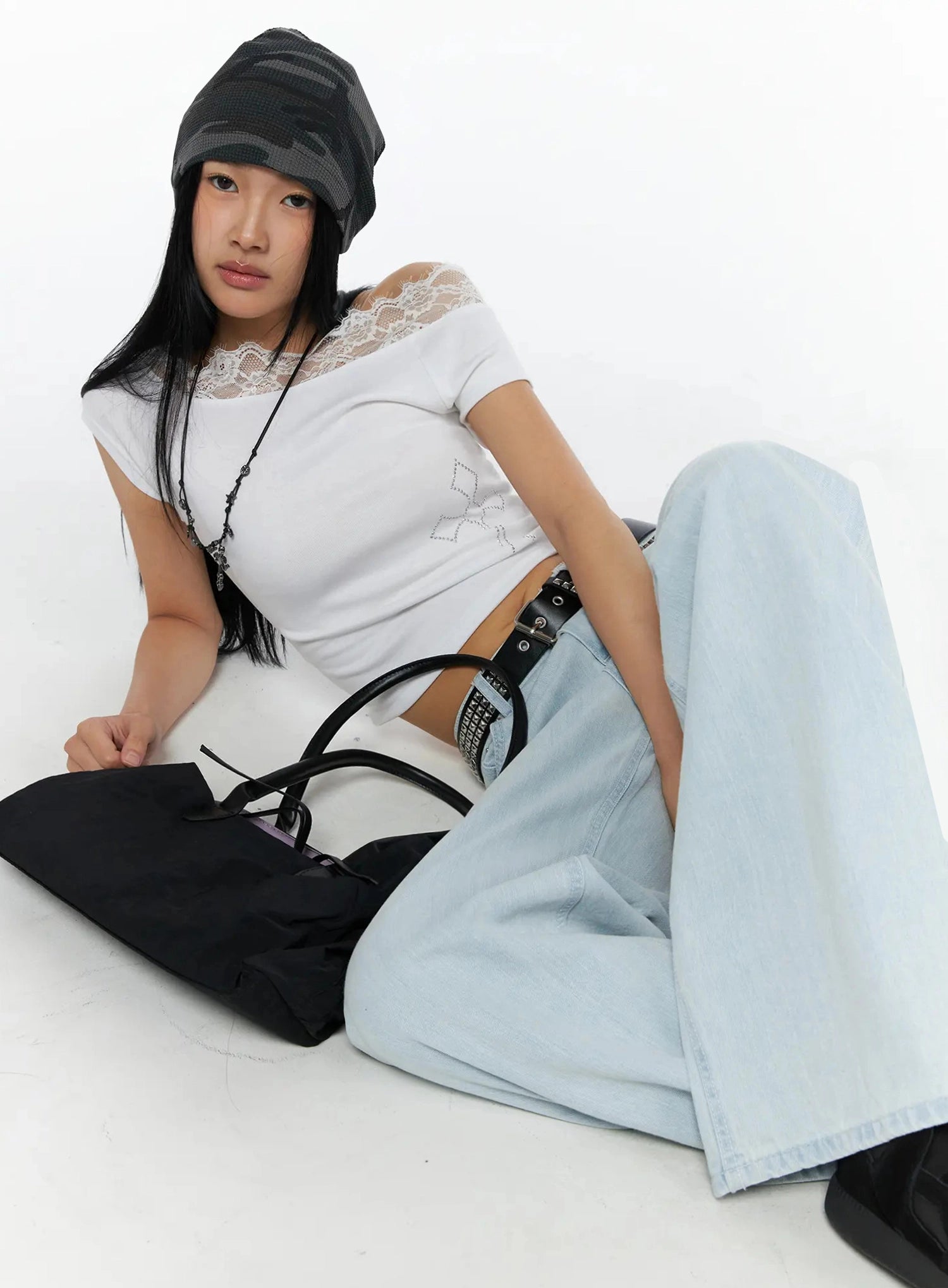 Keliana Soft Wide-Leg Jeans IL516 Light blue seated model in styled outfit with beanie, chain belt, cross necklace, and black bag