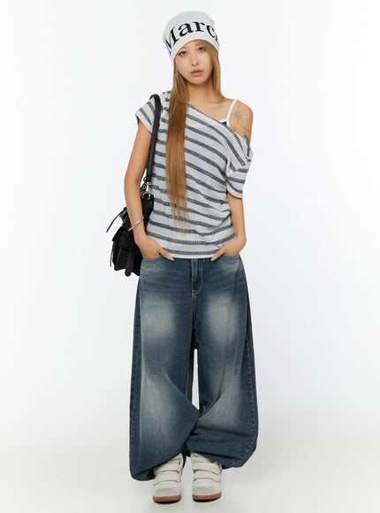 Kenji Baggy Wide-Leg Jeans IL524 Dark blue full-body front shot on model styled with striped off-shoulder knit top, beanie, black bag, and white sneakers