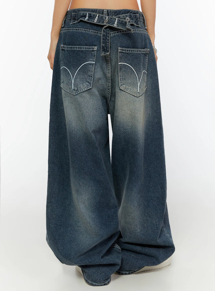 Kenji Baggy Wide-Leg Jeans IL524 Dark blue back close-up on model showing crossover waistband strap with metal buttons and arc-embroidered dual back pockets