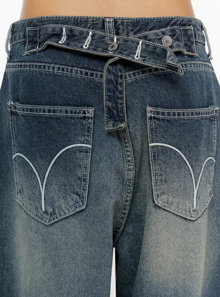 Kenji Baggy Wide-Leg Jeans IL524 Dark blue close-up detail of back waistband with crossover strap, dual buttons, and arc-embroidered back pockets on model