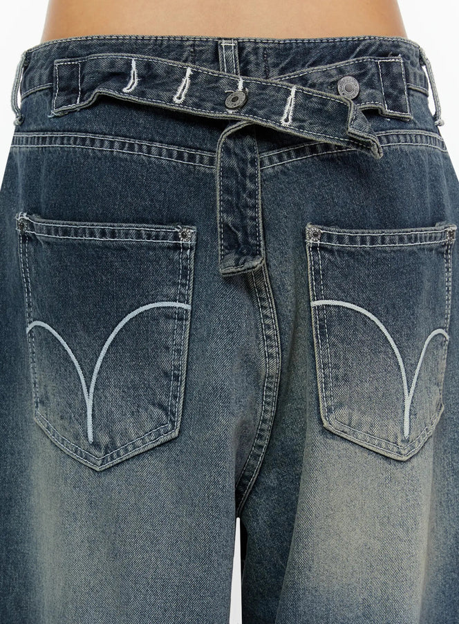 Kenji Baggy Wide-Leg Jeans IL524 Dark blue close-up detail of back waistband with crossover strap, dual buttons, and arc-embroidered back pockets on model