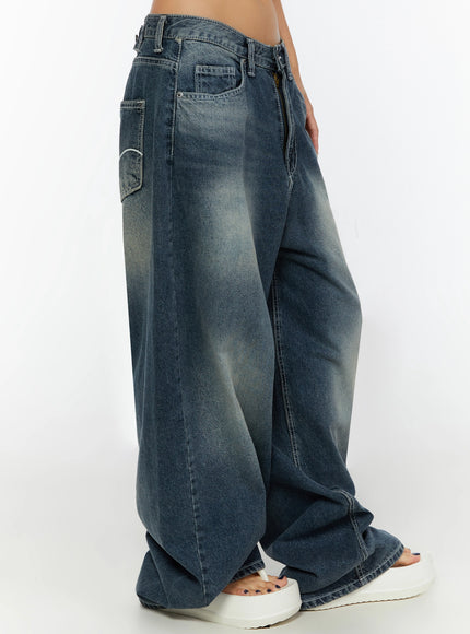 Kenji Baggy Wide-Leg Jeans IL524 Dark blue side close-up on model showing side pocket, faded wash texture, curved seam detail, and pooling hem at white sandal