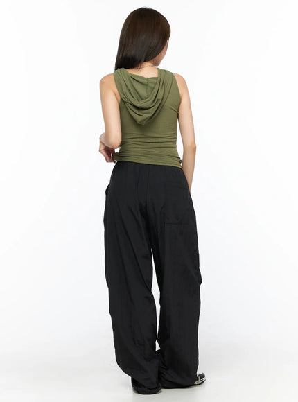 Keyhole Button Hooded Crop Sleeveless Top CL514 Dark green back model shot showing hood drape and ribbed texture styled with black parachute pants