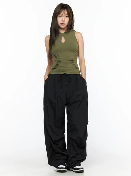 Keyhole Button Hooded Crop Sleeveless Top CL514 Dark green full-length front model shot with hood down keyhole neckline ruched sides styled with black wide-leg pants