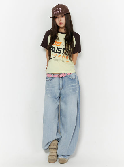 Kit Washed Wide Leg Jeans IL523 Light blue full front view on model wearing cap, front-facing pose, pink studded belt, wide balloon leg washed jeans