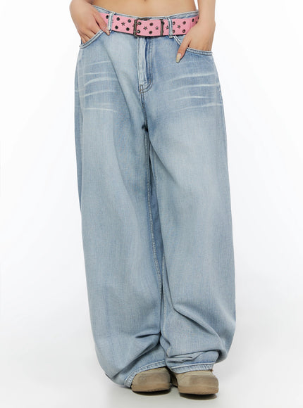 Kit Washed Wide Leg Jeans IL523 Light blue front cropped view on model, hands in pockets, pink star-stud belt at low waist, washed crease detail on thighs