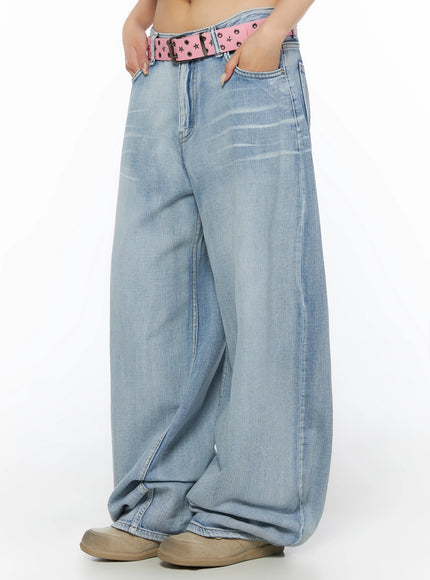 Kit Washed Wide Leg Jeans IL523 Light blue side close-up on model, hands on hips, washed wide-leg denim with pink star-stud belt, pocket and seam detail visible