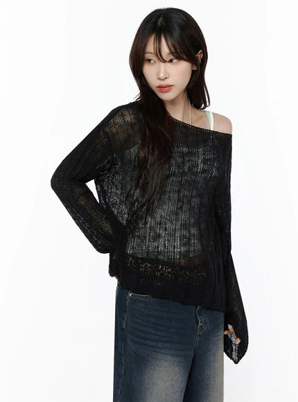 Knit Boat Neck Sweater IL506 black three-quarter front shot on model hand on hip, sheer open-knit fabric, layered over white cami, paired with wide-leg jeans