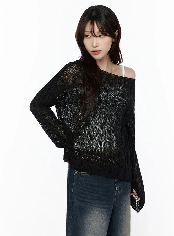 Knit Boat Neck Sweater IL506 black three-quarter front shot on model hand on hip, sheer open-knit fabric, layered over white cami, paired with wide-leg jeans