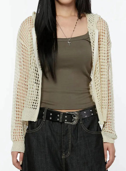Knit Net Zip-Up Hoodie IL516 Light beige close-up front torso shot on model, open-weave mesh texture and zip placket detail visible over khaki crop tank with studded belt