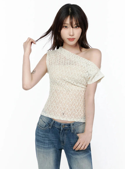 Lace Asymmetrical Off-Shoulder Top IL506 Light beige half-body front shot on model hand touching hair showcasing off-shoulder neckline and floral lace fabric
