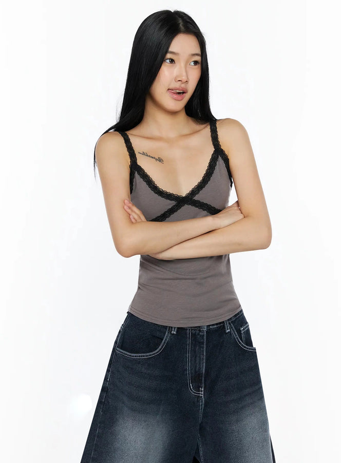 Lace Contrast Cami Top IL509 gray front shot on model with arms crossed showing black lace X-strap trim paired with wide-leg jeans